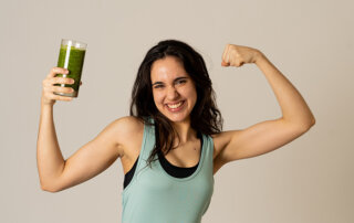 a woman holding a Super Greens smoothie